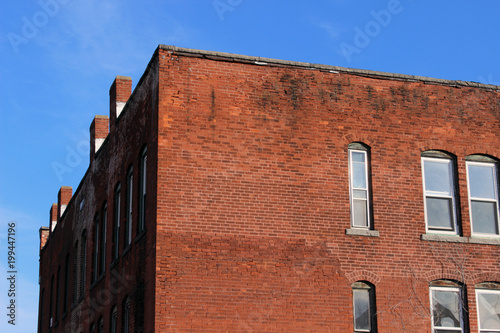 Boarded up windows on abandoned industrial urban brick factory building 