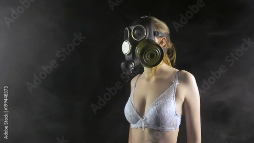 Young girl in gas mask wearing white bra