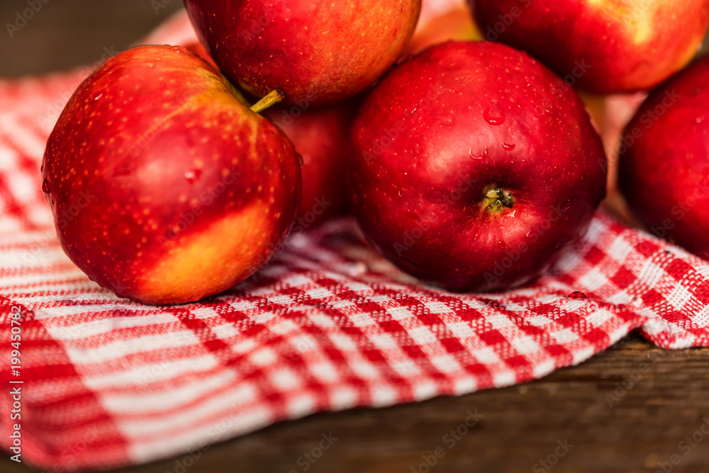 Whole ripe red apples on checked tablecloth close Whole ripe red apples on checked tablecloth close
