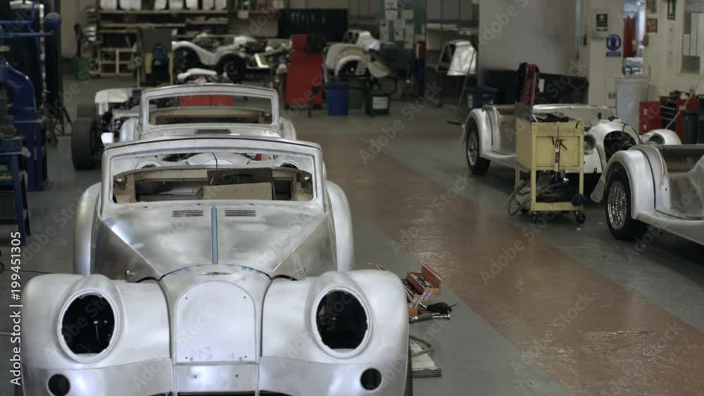 Car manufacturing plant engineers working on vehicles Car manufacturing plant engineers working on vehicles