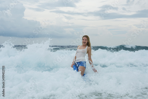 Young woman in a white shirt is bathed in the ocean © Andriy Nekrasov
