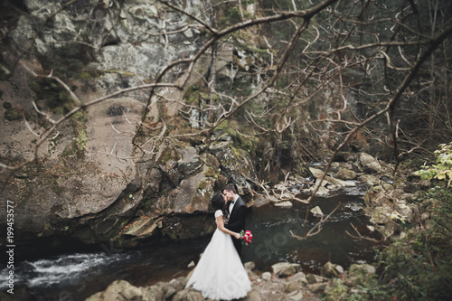 Wedding couple  groom and bride hugging  outdoor near river