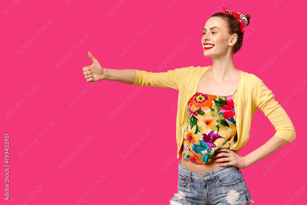 Young beautiful girl in yellow sweater on pink background shows ok. Colour obsession concept. Minimalistic style, Stylish Trendy Young beautiful girl in yellow sweater on pink background shows ok. Colour obsession concept. Minimalistic style, Stylish Trendy