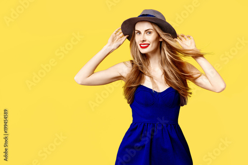 Young woman on a yellow background with a hat smiling. Concept of healthy nutrition and sports.  Colour obsession concept.  Minimalistic style. Stylish Trendy © khmelev