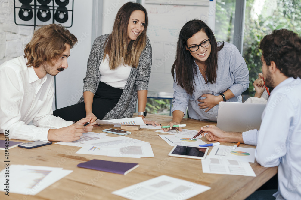 Young pregnant woman at work with his associates in the office during a meeting Young pregnant woman at work with his associates in the office during a meeting