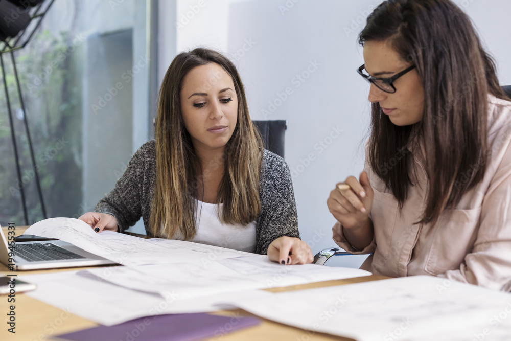 Meeting in a modern office of young architect and engineer while working on a project Meeting in a modern office of young architect and engineer while working on a project