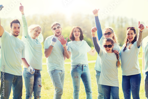 volunteering, charity, people, gesture and ecology concept - group of happy volunteers showing thumbs up in park