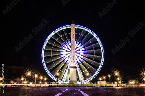 ferris wheel and obelisk in Paris, France by night