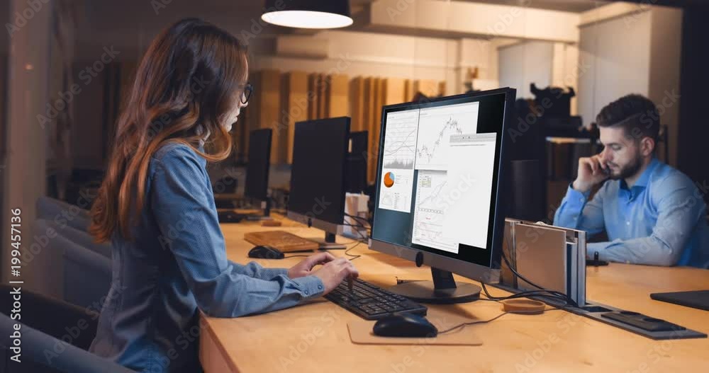 Man and woman colleagues professionals working together in modern office. Custom screen interface design. 4K UHD