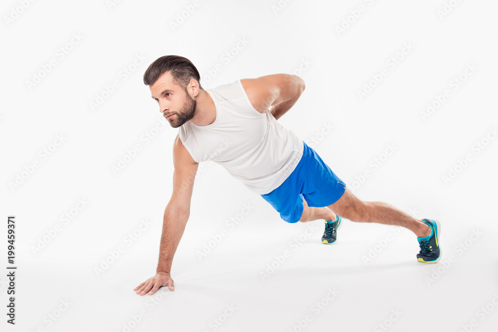 Half turned fullbody portrait of concentrated, confident, sporty, attractive, professional, successful man showing push up on one arm, having hand behind the back, isolated on white background Half turned fullbody portrait of concentrated, confident, sporty, attractive, professional, successful man showing push up on one arm, having hand behind the back, isolated on white background