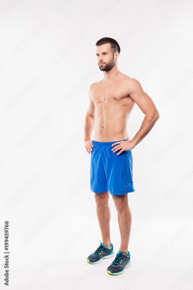 Fullbody, full size portrait of half turned, attractive, athletic, sportive man in blue shorts holding hands on waist, looking to the side, having modern hairstyle, standing on white background Fullbody, full size portrait of half turned, attractive, athletic, sportive man in blue shorts holding hands on waist, looking to the side, having modern hairstyle, standing on white background