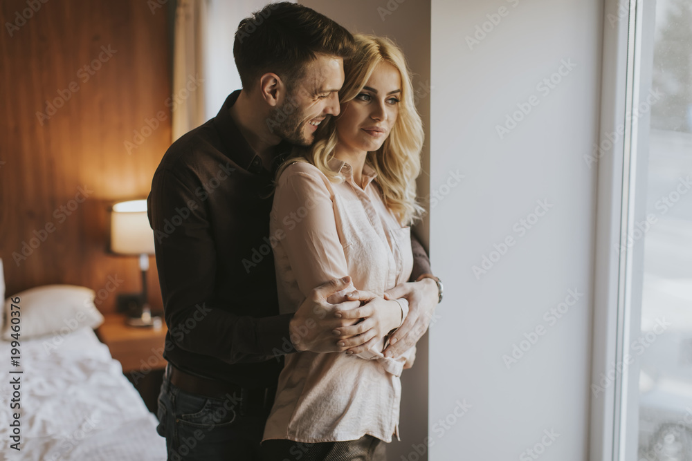 Loving couple by window in the room