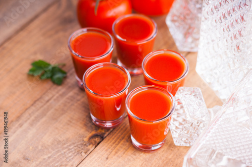 Photos Cold Bloody Mary cocktail shot in glasses and tomatoes