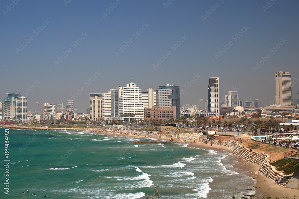 Malowniczy widok zatoki Morza Śródziemnego, plaża, nabrzeżę i nowoczesna architektura w Tel Awiwie, Izrael, na piaszczystej plaży odpoczywający ludzie, fale na morzu, niebieskie niebo - obrazy, fototapety, plakaty 