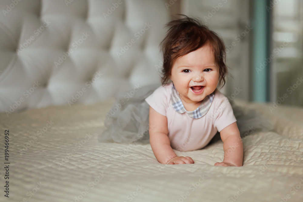 Smiling baby girl in her bed. Portrait of happy beautiful little child Smiling baby girl in her bed. Portrait of happy beautiful little child