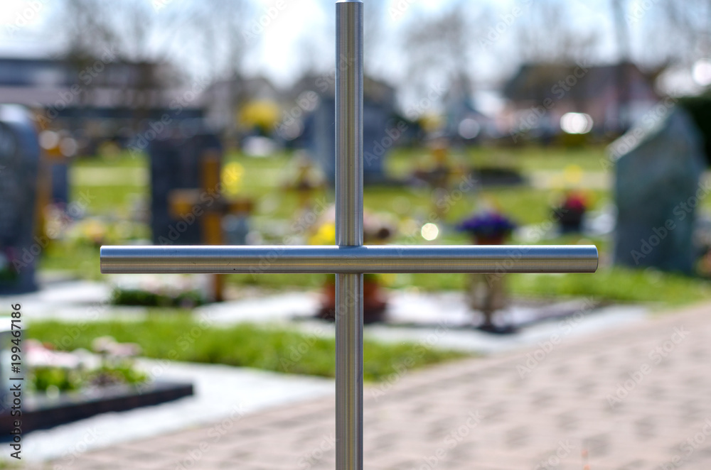 Simple metal cross on a grave in a cemetery Simple metal cross on a grave in a cemetery