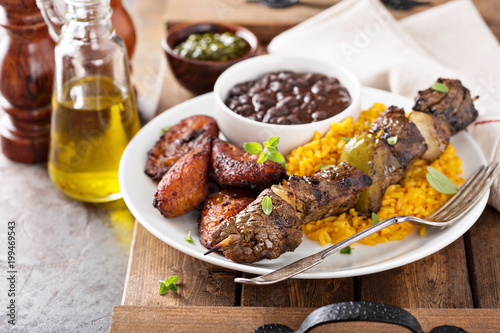 Beef kebab with rice, beans and fried plantains
