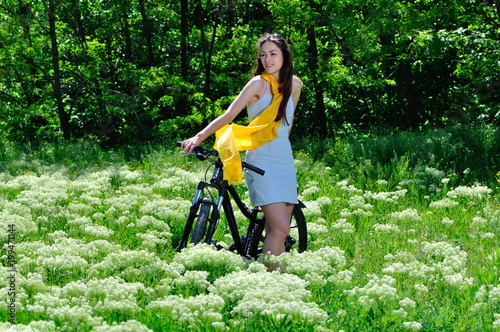 Girl among the wild flowers on a bike