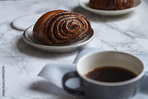 Breakfast with sweet rolls with poppy seeds on marble table photo