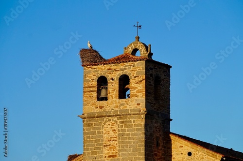 Campanario con cigüeña y veleta de un pueblo español de la meseta