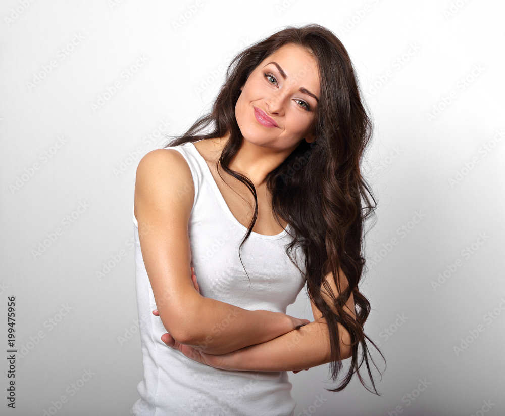 Beautiful positive happy laughing woman in white shirt with folded arms the long brown hair on white background. Beautiful positive happy laughing woman in white shirt with folded arms the long brown hair on white background.