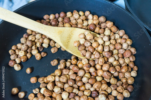 fry hazelnuts in a frying pan. fresh nuts in the pan.
