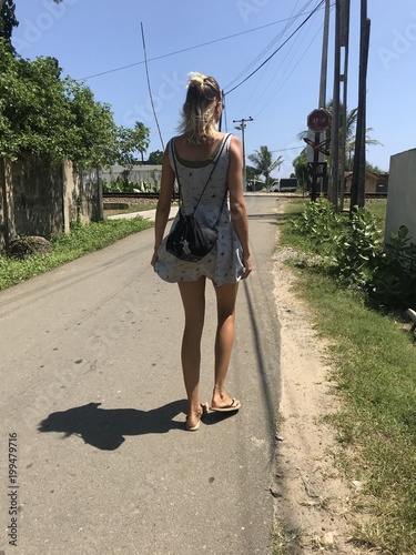 Woman walking on the street in a tropical country. photo