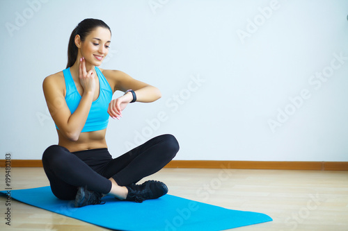 Beautiful athletic girl looking at watches