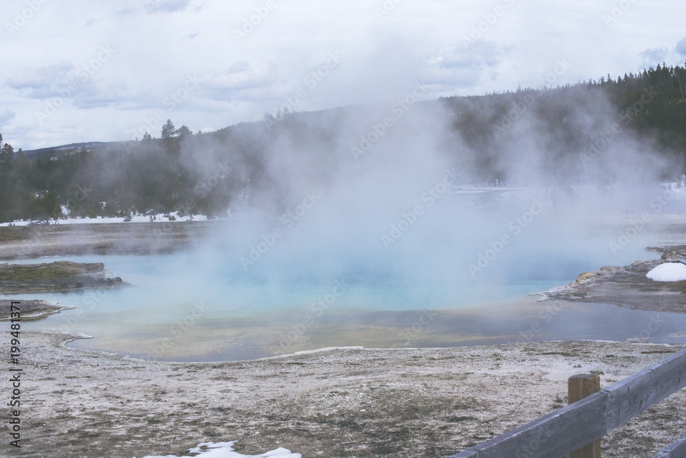 Hot Spring at Yellowstone National Park in Winter with snow and clear sky