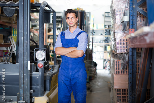 Portrait of attentive male in uniform on his workplace in building store.