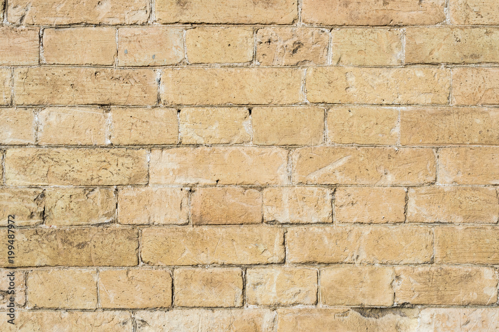 Textured background of a stone brick of yellow antediluvian masonry. Partially destroyed wall. Brick grunge background in vintage style Textured background of a stone brick of yellow antediluvian masonry. Partially destroyed wall. Brick grunge background in vintage style