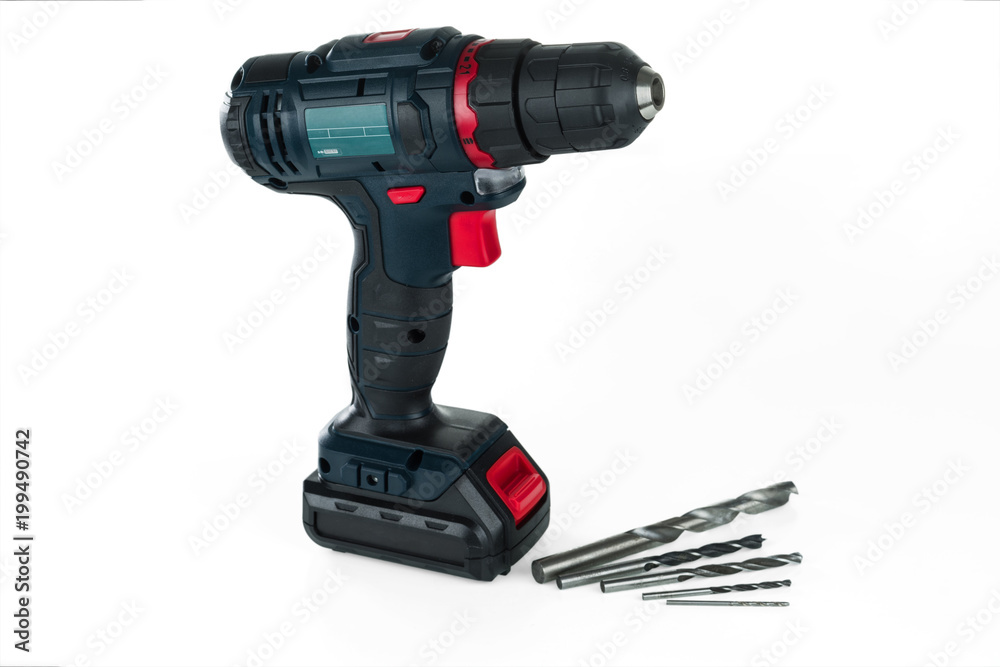 Cordless drill and a set of different drills isolated on white background.