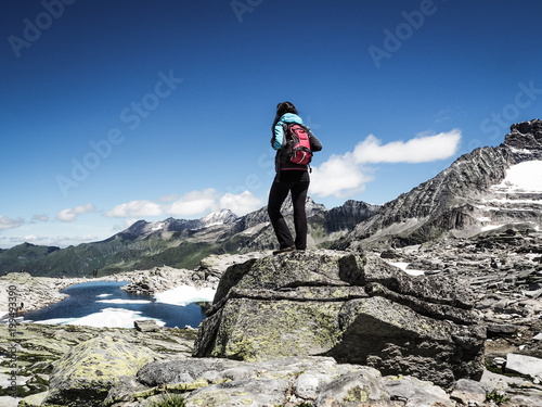 sportive woman standing on top of a mountain in the alps and enjoying the view
