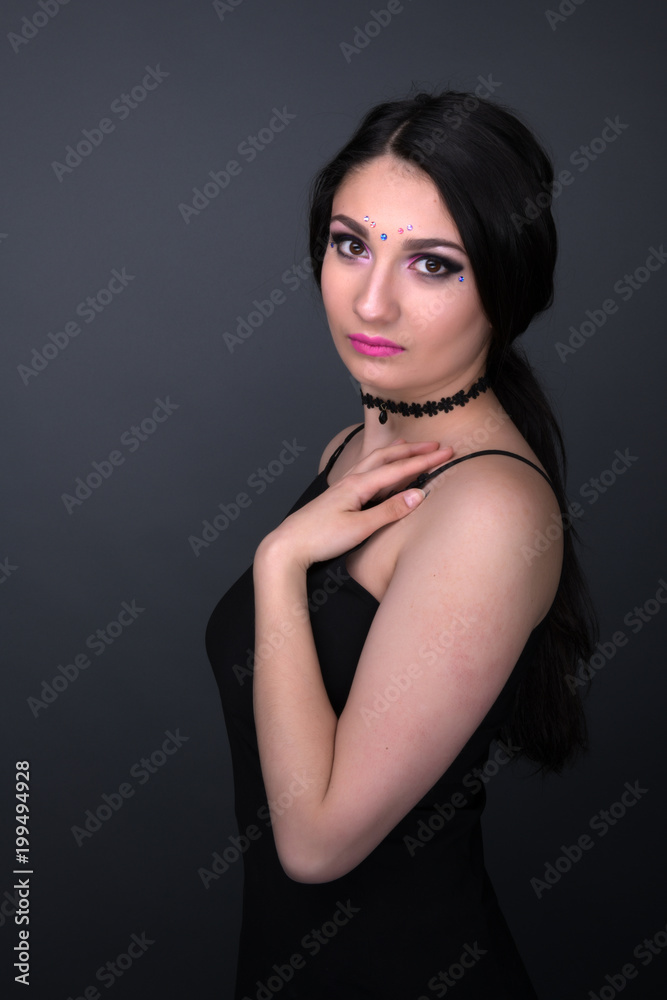 Close up face. Young arabic woman in black sexy dress, isolated on gray  background Stock Photo | Adobe Stock