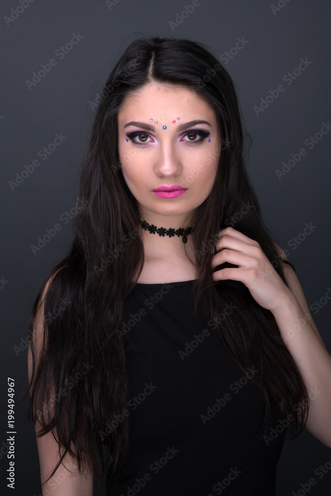 Close up face. Young arabic woman in black sexy dress, isolated on gray background Close up face. Young arabic woman in black sexy dress, isolated on gray background