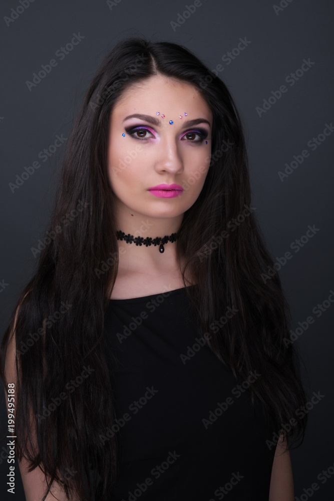 Close up face. Young arabic woman in black sexy dress, isolated on gray background Close up face. Young arabic woman in black sexy dress, isolated on gray background
