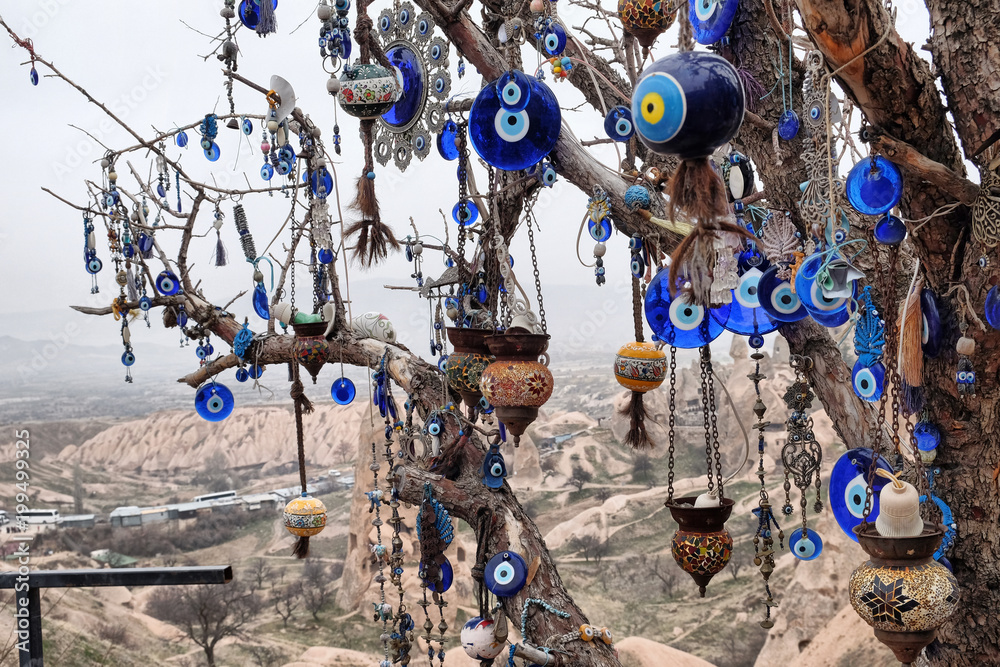 Nazar, charms to ward off the evil eye , on the branches of a tree in Cappadocia, Turkey Nazar, charms to ward off the evil eye , on the branches of a tree in Cappadocia, Turkey