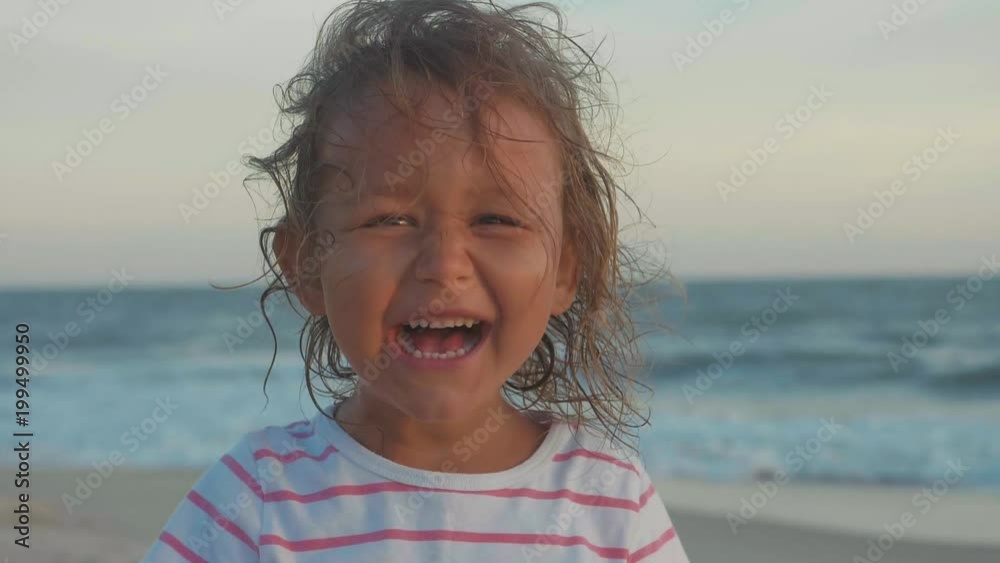Portrait of happy little child girl looking at camera and laughing at beach Portrait of happy little child girl looking at camera and laughing at beach