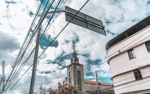 Wide-angle view of a concrete tower with cross of an abandoned church 