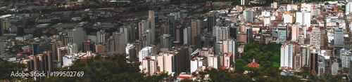 The panorama of Juiz de Fora city in Minas Gerais state of Brazil: plenty of multistorey building, parks, favelas, church, offices, and blocks of flats, chaotic mass scale, roads and streets