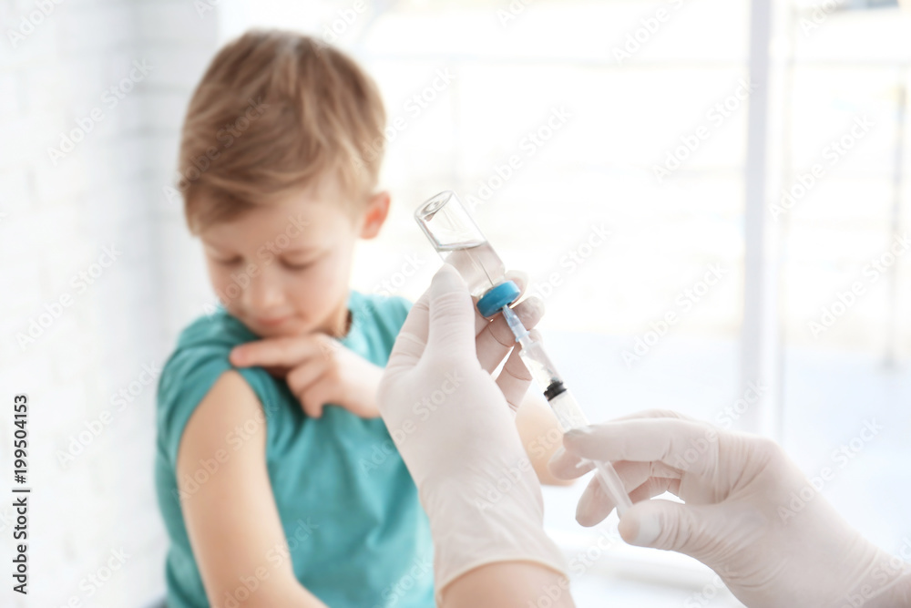 Doctor filling syringe with medicine and child on background. Vaccination day Doctor filling syringe with medicine and child on background. Vaccination day