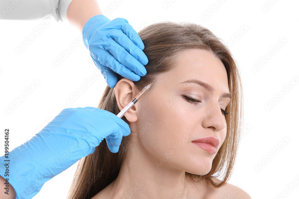Young woman with hair loss problem receiving injection on white background