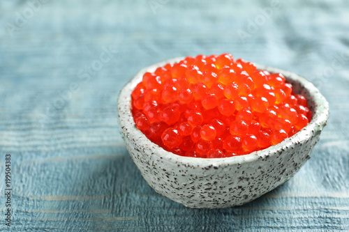 Ceramic bowl with delicious red caviar on table