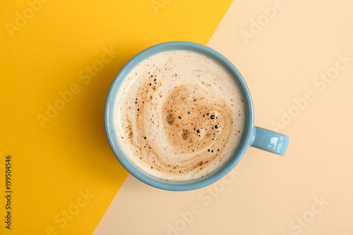 Cup of aromatic hot coffee on color background, top view
