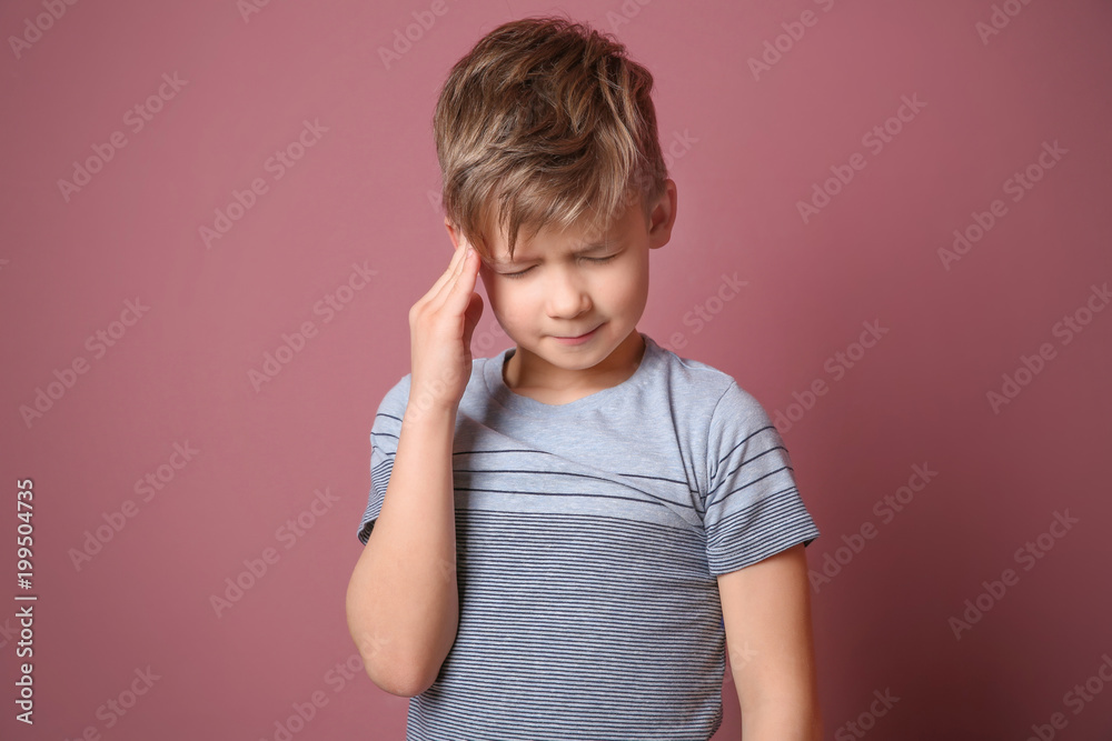 Little boy suffering from headache on color background Little boy suffering from headache on color background