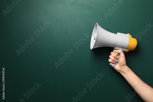 Man holding megaphone near chalkboard