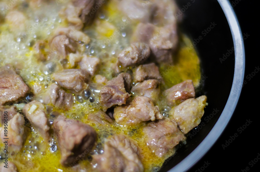 Juicy pork cut into pieces fried in butter, red meat prepared in a pan Juicy pork cut into pieces fried in butter, red meat prepared in a pan