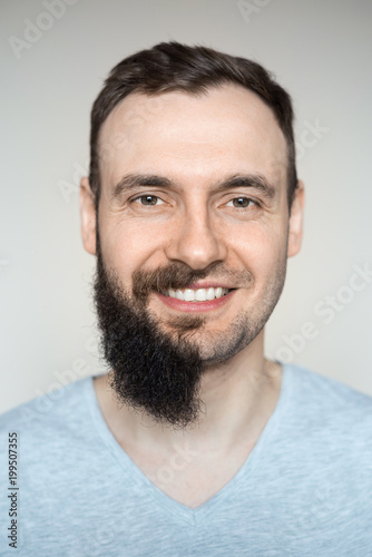 Beautiful portrait of a man teeth smile with a full beard and no beard after shaving with light stubble. Barber working on a white background. photo