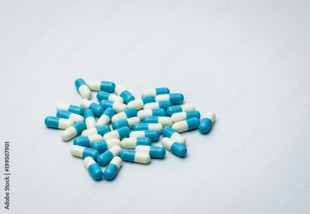 Blue and white capsules pills isolated on white background with copy space for text. Global healthcare concept. Antibiotics drug resistance concept. Antimicrobial capsule pills.