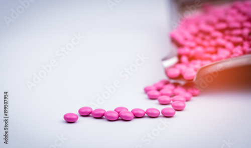 Pile of pink round sugar coated tablets pills on drug tray with copy space. Pills for treatment antianxiety, antidepressant and migraine headache prophylaxis. Healthcare in seniors or older people photo